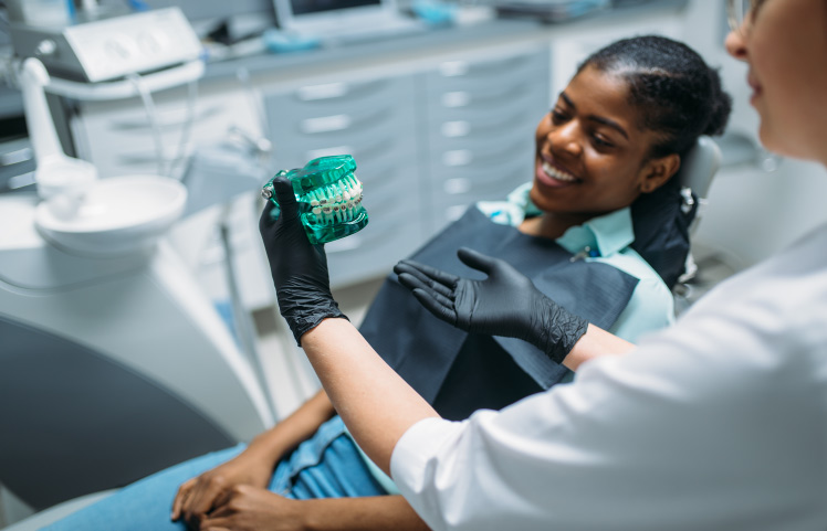 dentist showing patient model of teeth